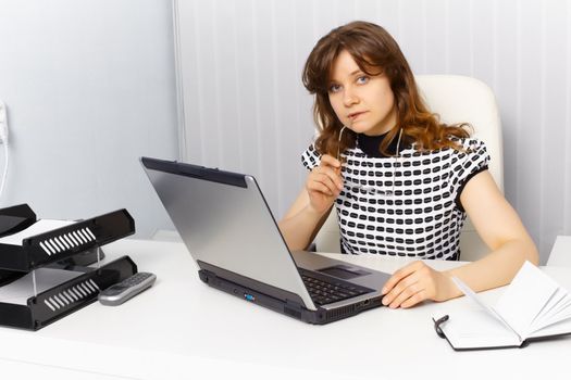 Female secretary working in an office with a laptop