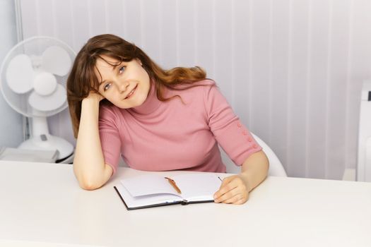 A beautiful young woman sitting at table