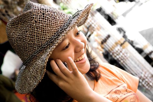 modern lifestyle portrait of female asian teen seems to enjoy her phone call conversation with friends