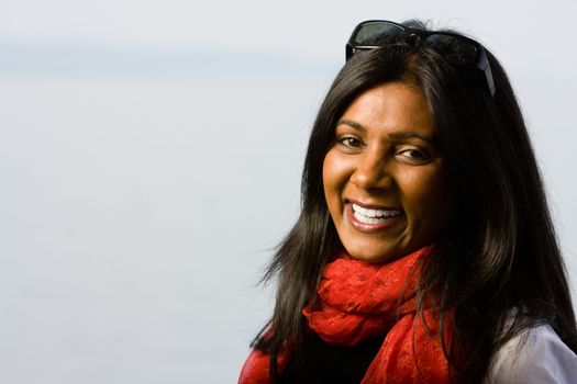 Pretty indian girl smiling outdoors in the park against a nature background