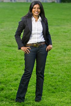 Pretty indian girl smiling outdoors in the park against a nature background