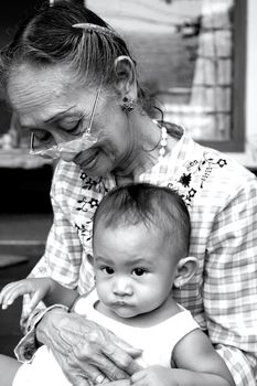sweet moment of baby and grandma relaxing together. showing differences and resemblance in between: old and new, softness and wrinkled, expression and character