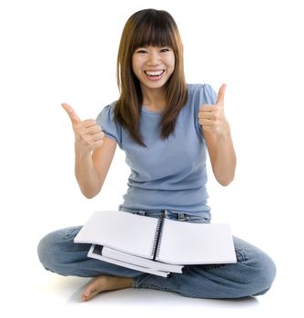 Asian student thumbs up with great smile, empty book ready for text.