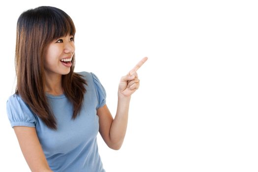 Asian student sitting on floor, pointing to empty space, ready for text.