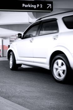 a silver car ready to turn following the directional sign above. copyspace on billboard