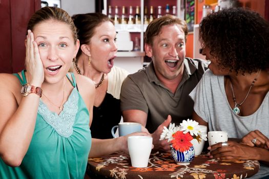 Four adult gossiping friends meeting in a coffee house