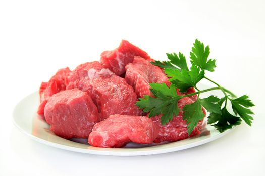 raw beef stew with lovage on a white plate