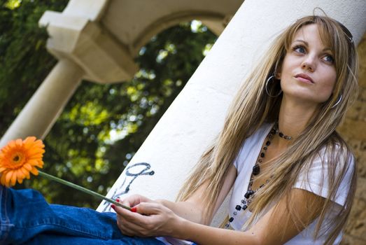 beautiful young woman with books and flower outdoor