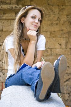 beautiful young woman with books and flower outdoor