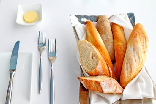 Sliced baguette with butter and knife