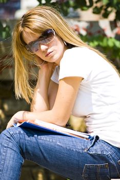 beautiful young woman reading book outdoor