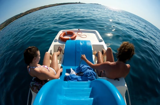 Women enjoying their bicycle boat trip in Sardinia, Italy.