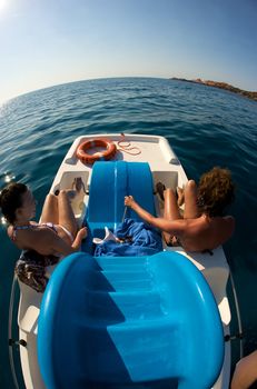 Women enjoying their bicycle boat trip in Sardinia, Italy.