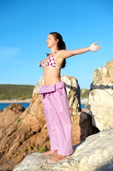 Beautiful young woman doing yoga exercise outdoors