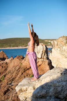 Beautiful young woman doing yoga exercise outdoors