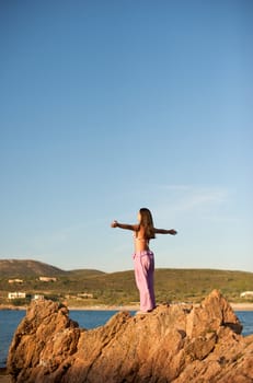 Woman relaxing on the rock with a sea view