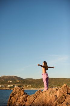 Woman relaxing on the rock with a sea view