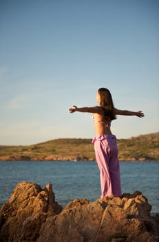 Woman relaxing on the rock with a sea view