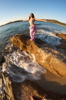 Woman relaxing on the rock with a sea view