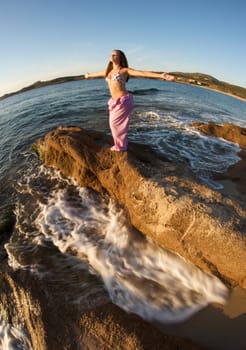 Woman relaxing on the rock with a sea view