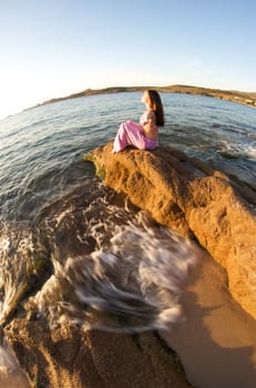 Woman relaxing on the rock with a sea view