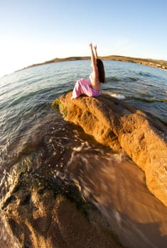 Woman relaxing on the rock with a sea view