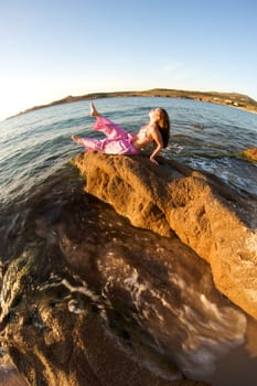 Woman relaxing on the rock with a sea view