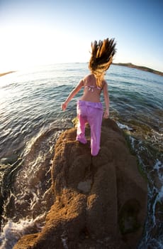 Woman relaxing on the rock with a sea view