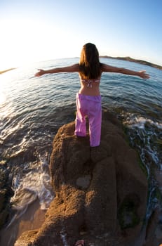 Woman relaxing on the rock with a sea view