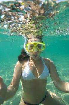 Woman doing snorkeling with goggles and scuba