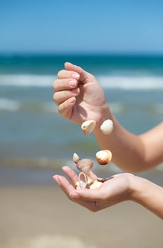 Woman playing with some shells on the beach