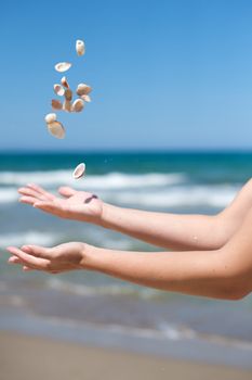 Woman playing with some shells on the beach