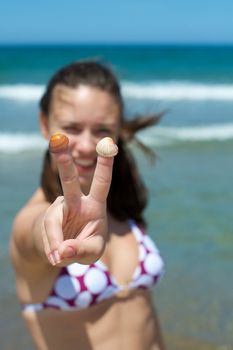 Woman playing with some shells on the beach