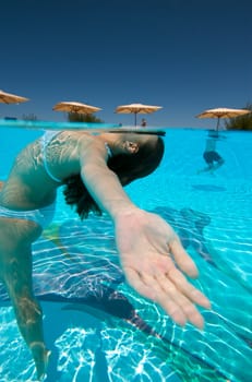 Underwater view of a woman swimming in the swimming pool