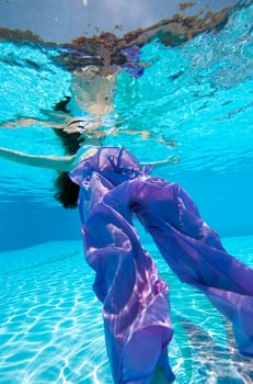 Underwater view of a woman swimming in the swimming pool