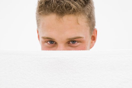 young man hiding himself behind a white towel