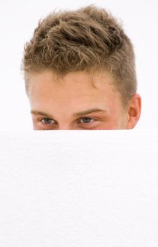 young man hiding himself behind a white towel