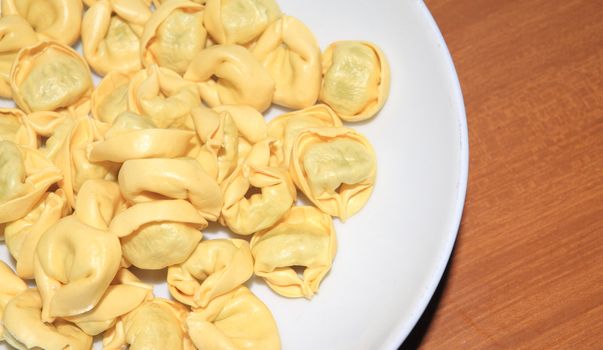 Tortellini with meat in a white dish