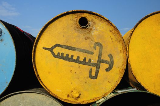 Symbol of a syringe, painted on the side of an old oil drum used as a waste bin for used needles at a music festival.