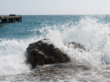 cold sea waves crashing against the coast stone