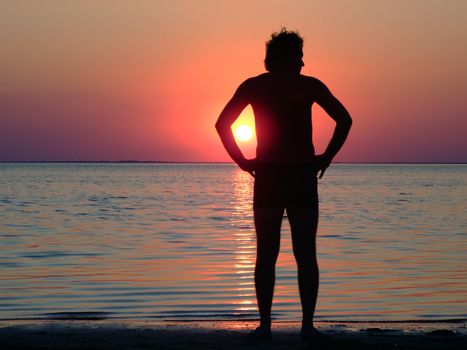 A black silhouette of a young guy on a sunset 1