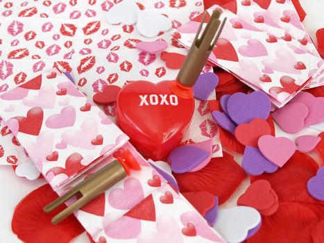 A plastic XOXO heart box with plastic darts shot at it, over a love themed background.