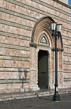 Italian cathedral's portal with streetlamp