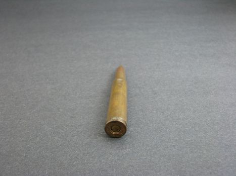 An old bullet straight against a dark background.