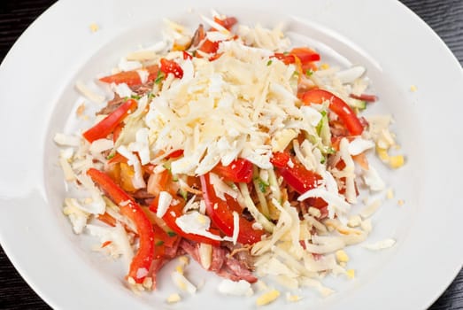 Salad from beef tongue, cervelat, chicken meat, fresh tomatoes, cucumbers, pepper, eggs, cheese and mayonnaise