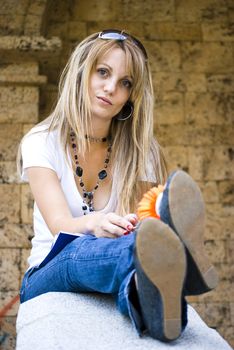 beautiful young woman with books and flower outdoor