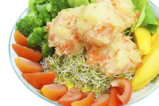 A plate of fresh vegetarian potato salad with fruits and vegetables.