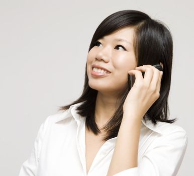 Asian business woman on the phone; looking at side.