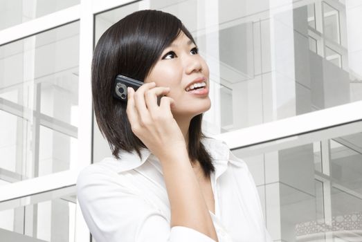 Asian business woman on the phone at modern building 