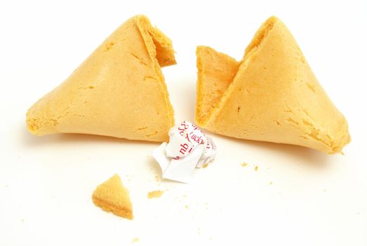 A fortune cookie cracked open with the message crumpled into a ball.